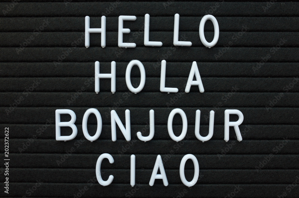 The words Hello, Hola, Bonjour and Ciao in white plastic letters on a black letter board as a friendly greeting from Europe The words Hello, Hola, Bonjour and Ciao in white plastic letters on a black letter board as a friendly greeting from Europe