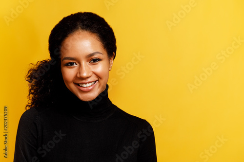Front view of a beautiful brunette woman over yellow background