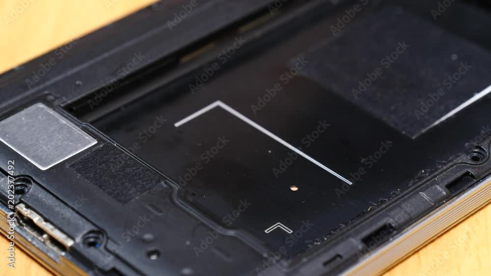 Male human hand disconnecting, putting out battery from phone. Smartphone fixing, technology repairing concept. Male human hand disconnecting, putting out battery from phone. Smartphone fixing, technology repairing concept.