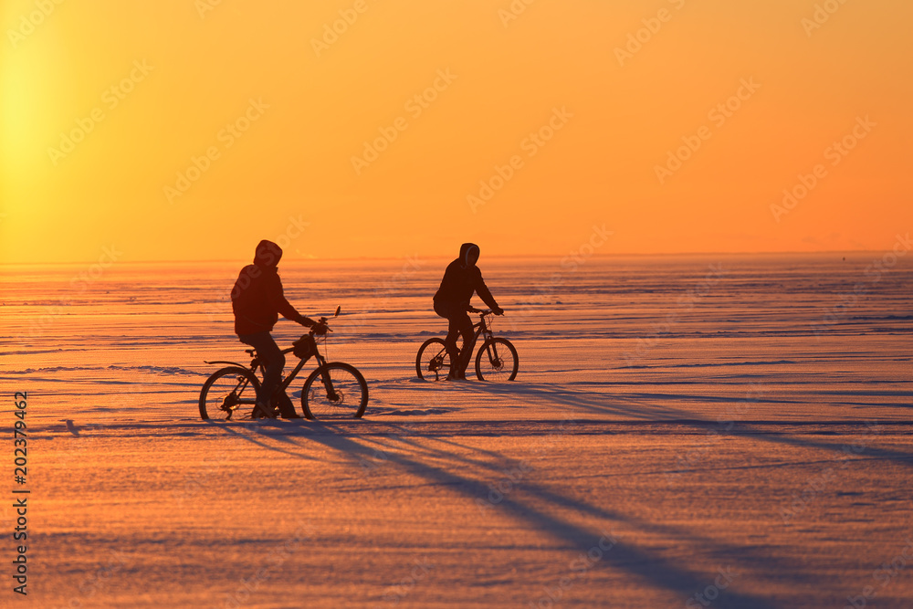 Fototapeta premium Silhouette of a bicyclists at sunset