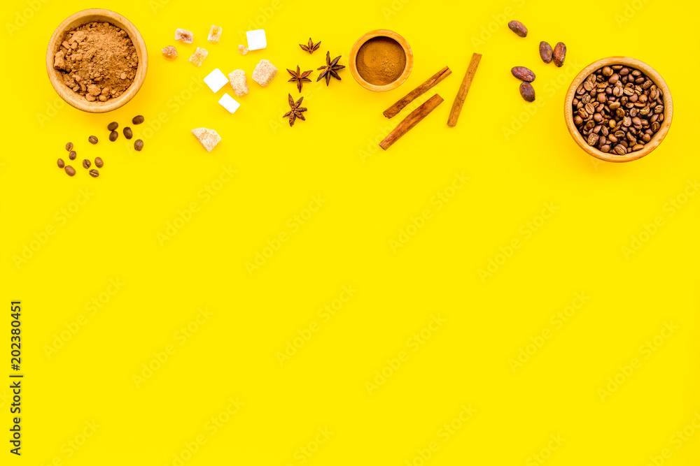 Fototapeta premium Flavouring products for making desserts. Cinnamon, cocoa, coffee on yellow table top view space for text
