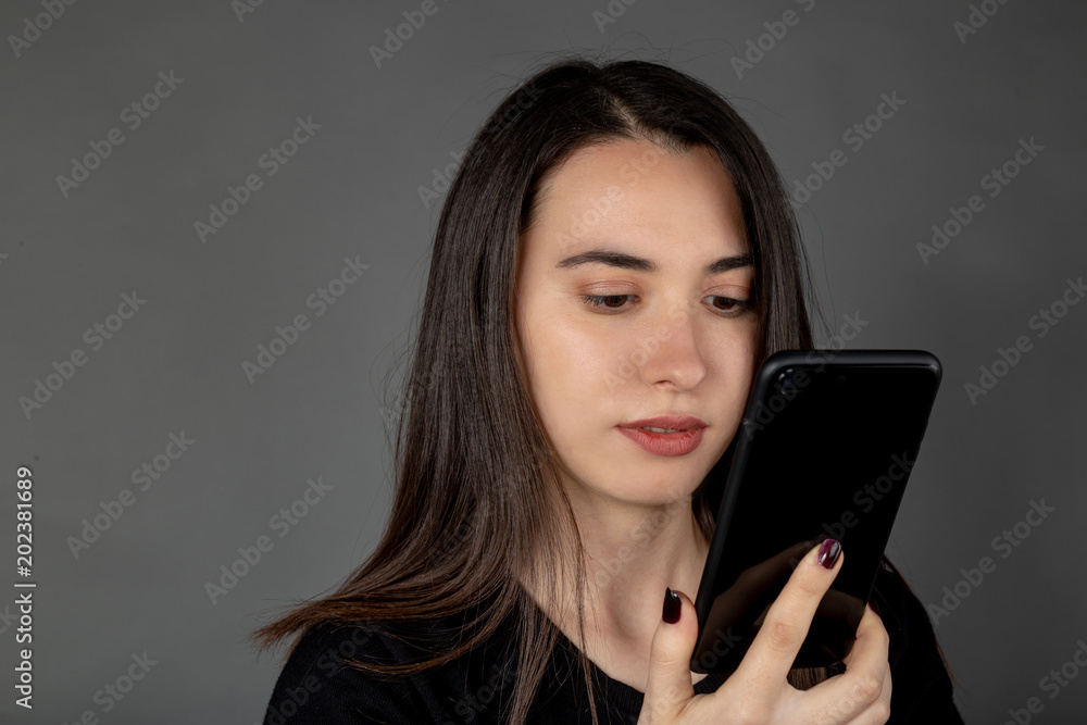 Beautiful young Turkish girl keeping and looking mobile phone on her hand Beautiful young Turkish girl keeping and looking mobile phone on her hand