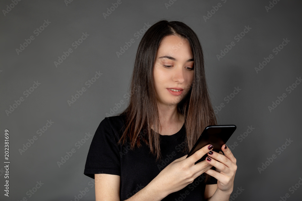Beautiful young Turkish girl keeping and looking mobile phone on her hand Beautiful young Turkish girl keeping and looking mobile phone on her hand