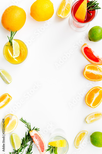 Concept of alcoholic cocktail with fruits. Glass with beverage near oranges, grapefruit, lime and rosemary on white background top view copy space © 9dreamstudio