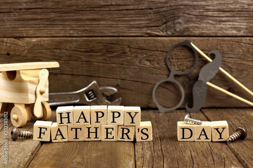 Happy Fathers Day wooden blocks with decor. Side view against a rustic wooden background.
