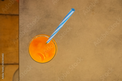 Fresh orange juice in glass on wooden background. orange juice top view. Gold summer drink. Healthy lifestyle concept.Copy space