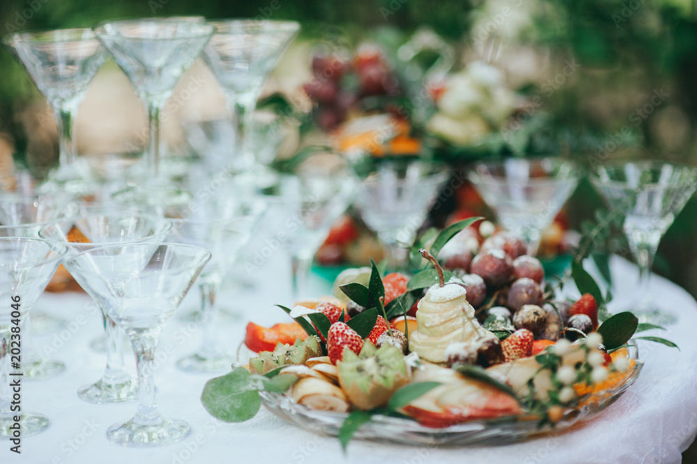 A plate of fruit on white. fruit slicing on a plate. wedding table A plate of fruit on white. fruit slicing on a plate. wedding table