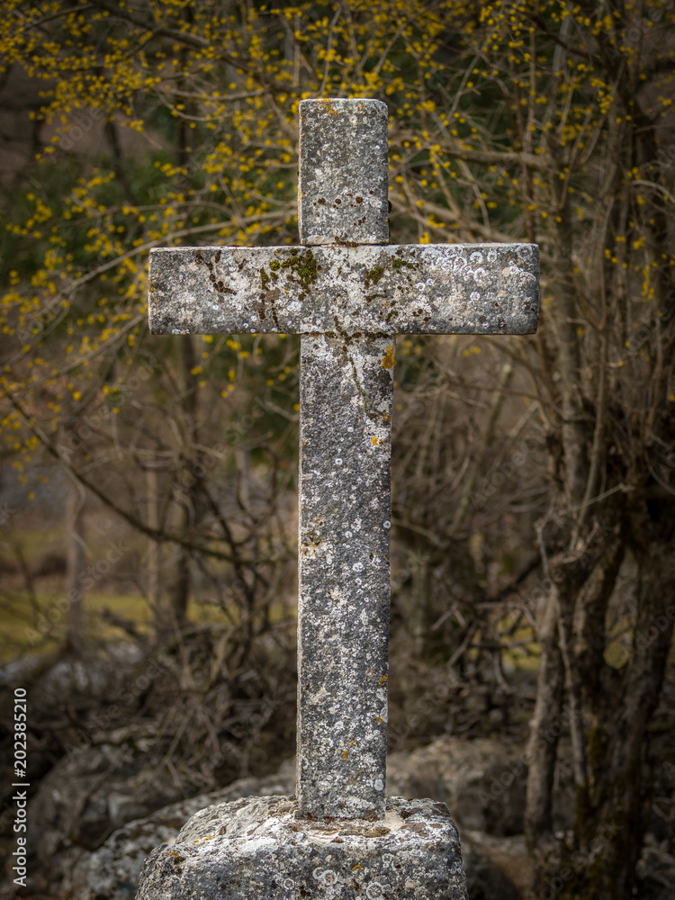 Small cross made of stone in a wood in spring Small cross made of stone in a wood in spring