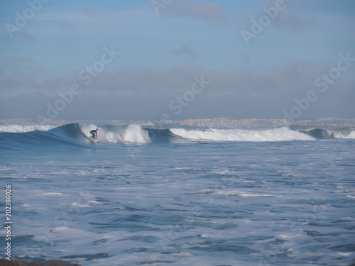 Surfer surfing waves at costa da caparica, nearby the city of lisbon