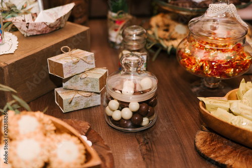 Wedding decor. Wedding interior. Festive decor. Table decor. Table with sweets and treats for guests. Candy bar Rustik. Selection focus