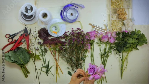 Overhead Hands of a florist puts together a bouquet of flowers photo