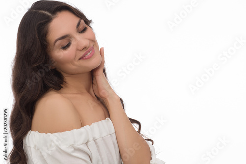 Bright brunette woman in white dress. Looking aside on white background. Mid age woman over 35 years old concept.