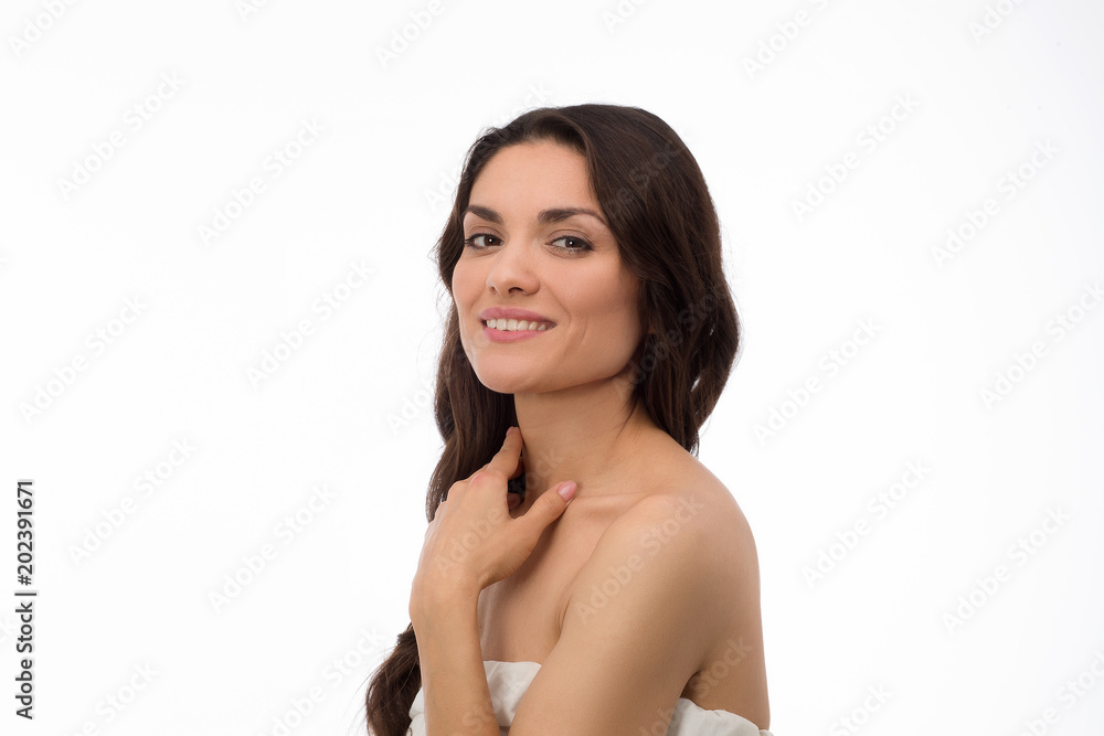 Obraz premium Female brunette in light white dress standing half turn and posing on camera. beauty concept. Mid age woman over 35 years old beauty concept.