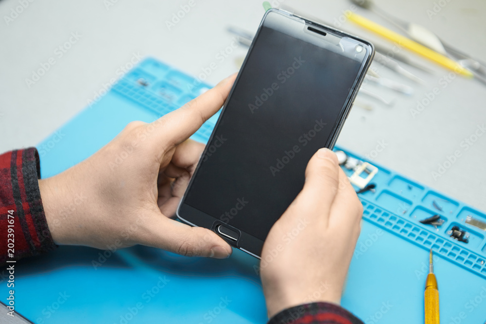 Cropped shot of unrecognizable male technician holding smart phone, going  to remove air bubbles in tempered glass fixed on gadget. People,  technology, repair and maintenance. Selective focus Stock Photo | Adobe  Stock