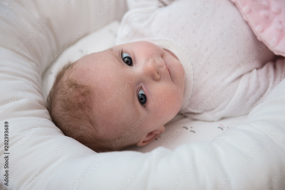 Little baby girl in white interior with blanket using pillow sleeping device Little baby girl in white interior with blanket using pillow sleeping device