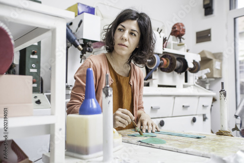 Woman designer making handmade shoes in her workshop