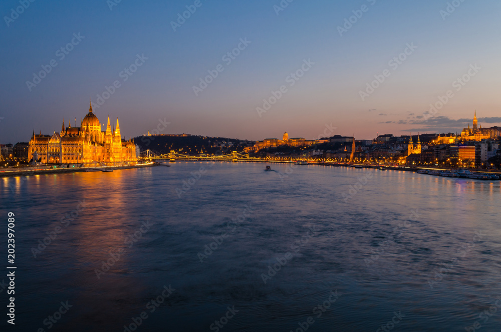 Budapest city at blue hour with illuminated Hungarian Parliament, Chain Bridge, Buda Castle, Fishermen's Bastion and Gellert Hill along Danube River, picturesque evening cityscape.