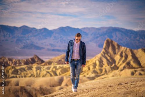 Young man walking alone in the desert of Death Valley