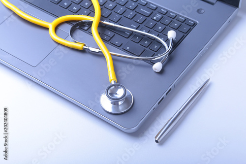 Workplace of doctor with laptop, stethoscope and RX prescription on white table. top view.