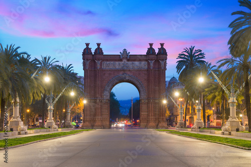 Bacelona Arc de Triomf at night in the city of Barcelona in Catalonia, Spain. The arch is built in reddish brickwork in the Neo-Mudejar style