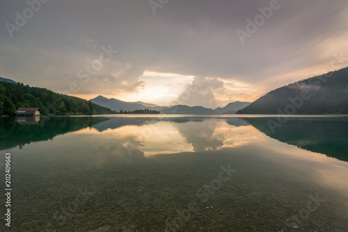 Sonnenaufgang mit Gewitter am See in den Bergen