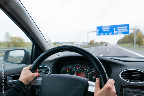 Driving on the highway seen by the eyes of young woman