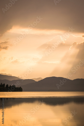 Sonnenaufgang und Gewitter am See in den Bergen