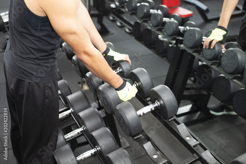 Man is selecting weight lifting in the gym.