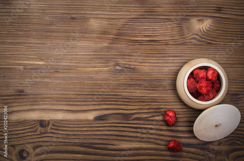 Fototapeta Naklejka Na Ścianę i Meble -  Herbal medicine concept. Dry strawberry in the jar on wooden brown table. Organic ingredients.
