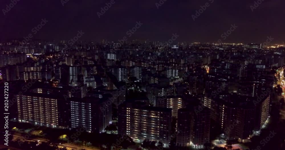Aerial cityscape of urban Singapore HDB apartment buildings lit up at night as seen from Jurong West. Drone shot. Aerial cityscape of urban Singapore HDB apartment buildings lit up at night as seen from Jurong West. Drone shot.