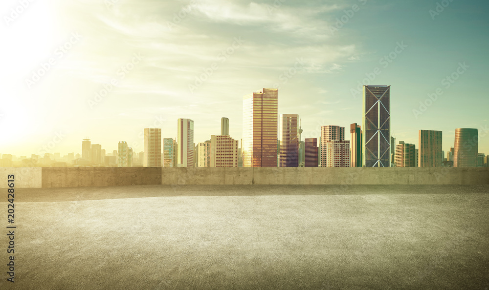 Empty asphalt carpark with modern city skyline , morning sunrise scene .