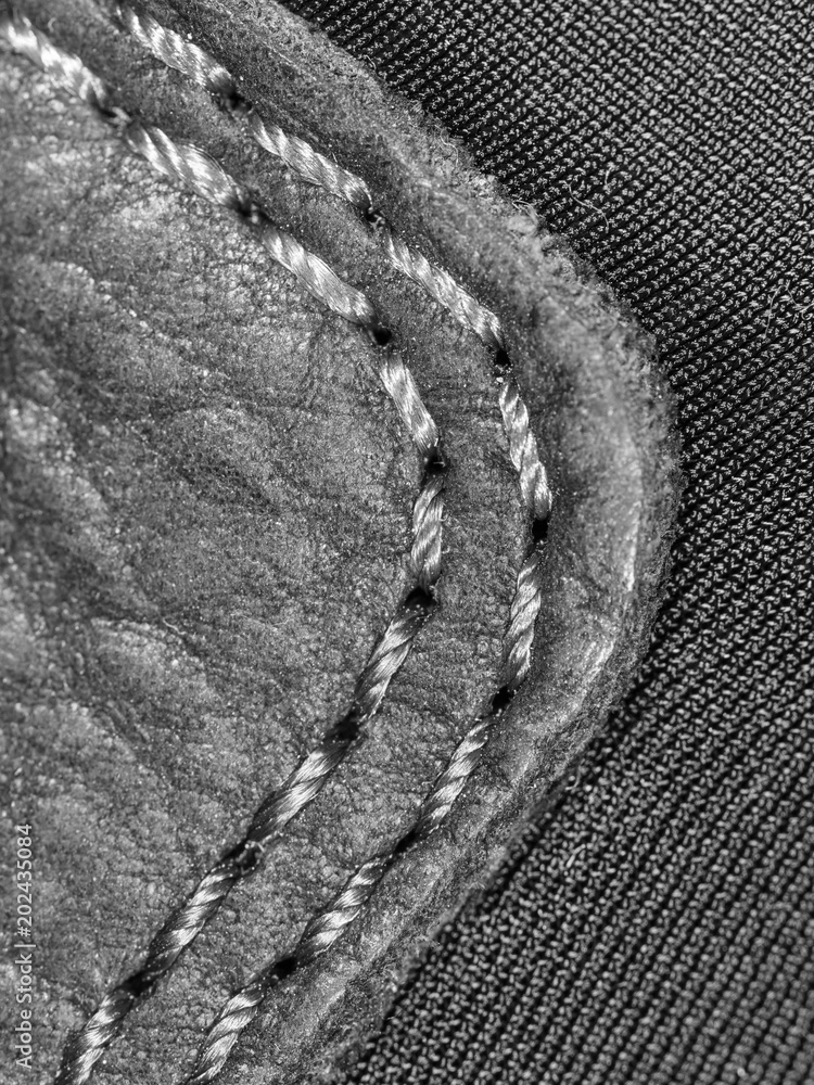 Thread seam on black leather material as background Thread seam on black leather material as background
