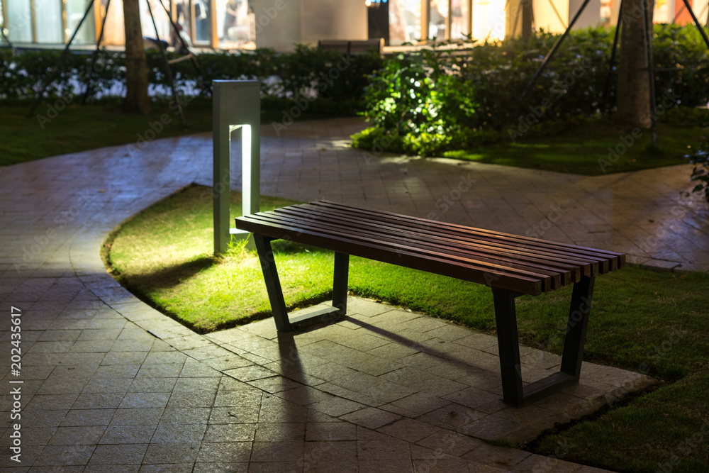 Garden glowing decoration light in the park at night with park bench