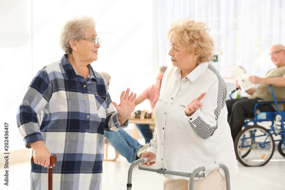 Senior women with walkers and cane talking at care home foto de Stock Adobe Stock