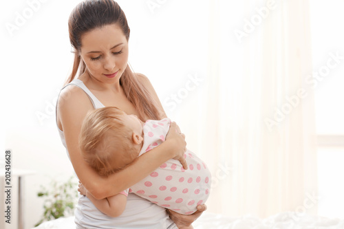 Young mother lulling her ba...