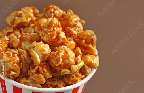 Delicious popcorn with caramel in paper bucket, closeup