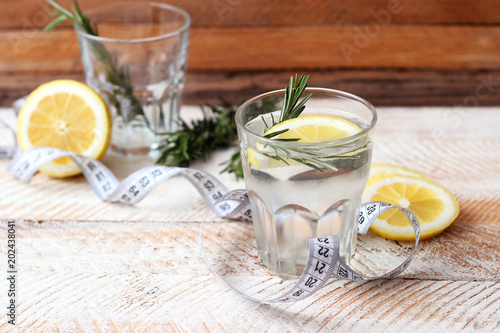  water with rosemary and lemon and centimeter tape with a place for inserting the text. concept of health, diet, fitness, healthy digestion, metabolism. minimalism, the top 
