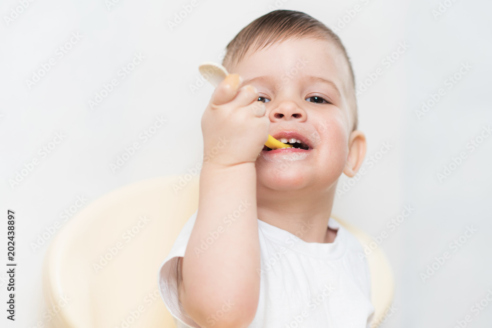 adorable baby boy eats porridge with a small spoon himself adorable baby boy eats porridge with a small spoon himself