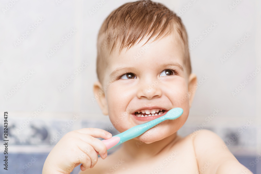 lovely baby brushing his teeth with a toothbrush in the bathroom lovely baby brushing his teeth with a toothbrush in the bathroom