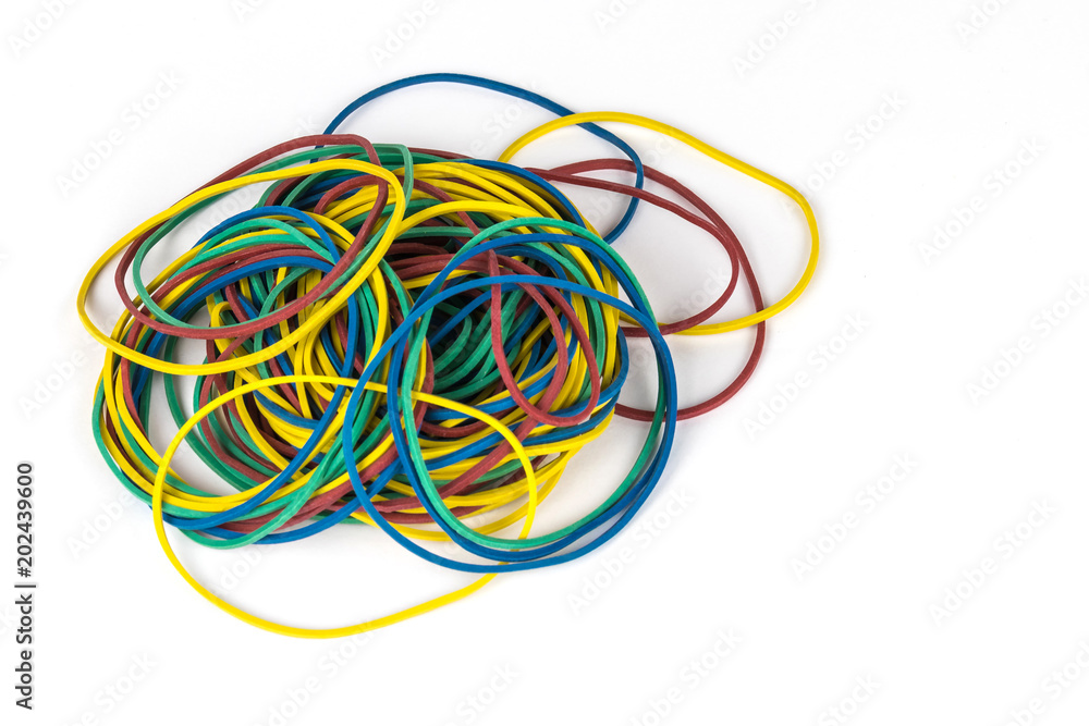 A pile of multicolored rubber money bands isolated on white