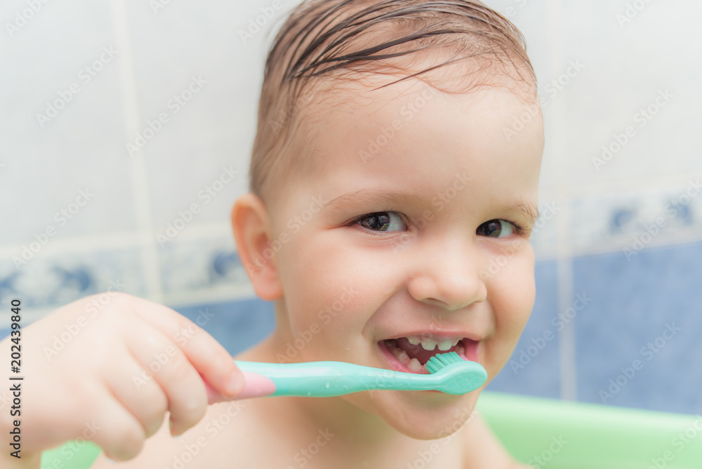 lovely baby brushing his teeth with a toothbrush in the bathroom lovely baby brushing his teeth with a toothbrush in the bathroom