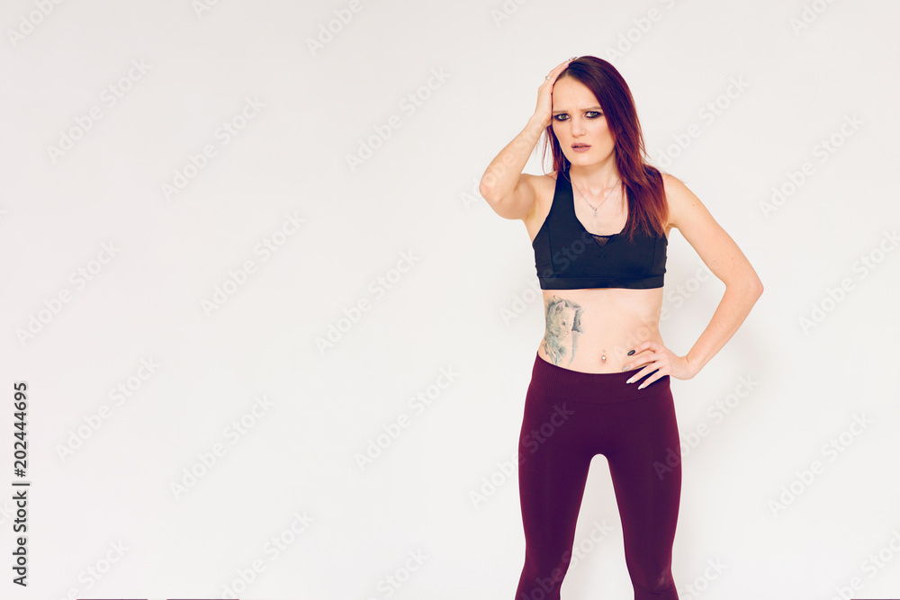beautiful fitness girl brunette shows emotions on a white background beautiful fitness girl brunette shows emotions on a white background