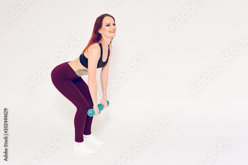 beautiful fitness girl brunette doing exercises with dumbbells