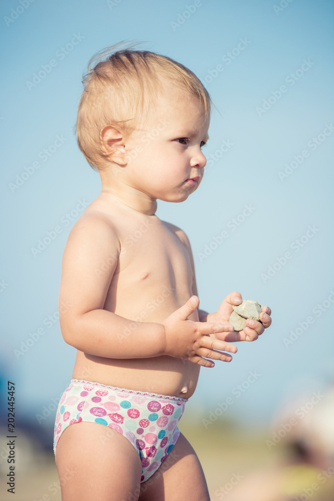 Baby playing with toys on the sandy beach near the sea. Cute little kid in sand on tropical beach. Ocean coast. Baby playing with toys on the sandy beach near the sea. Cute little kid in sand on tropical beach. Ocean coast.