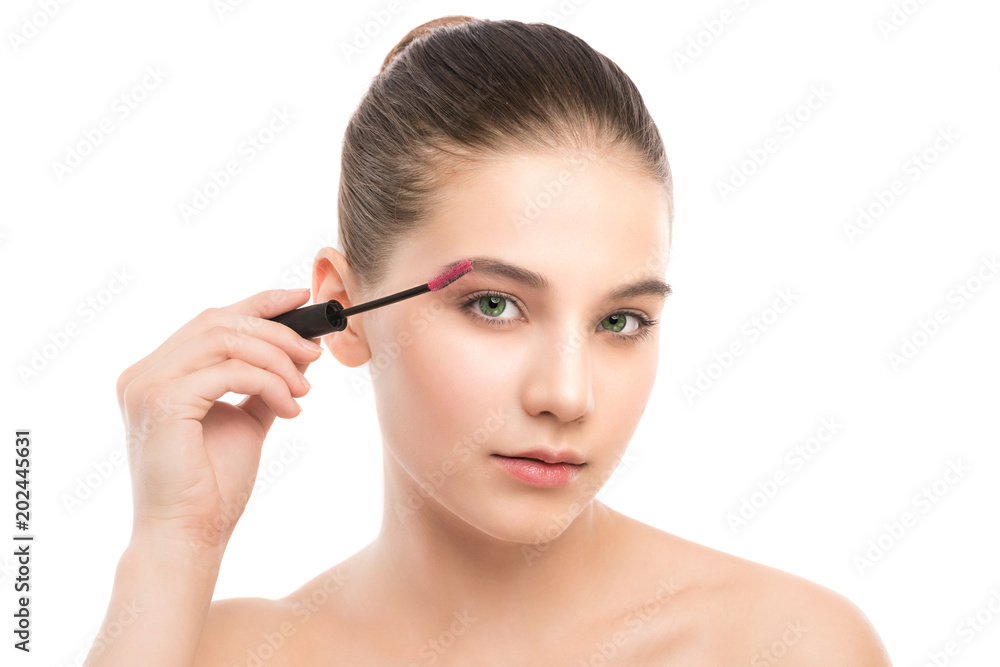 Eye make up apply. Mascara applying closeup, long lashes. Mascara brush. Portrait of beautiful young brunette woman with perfect fresh clean face skin. Eyelashes extensions. Make-up for green eyes