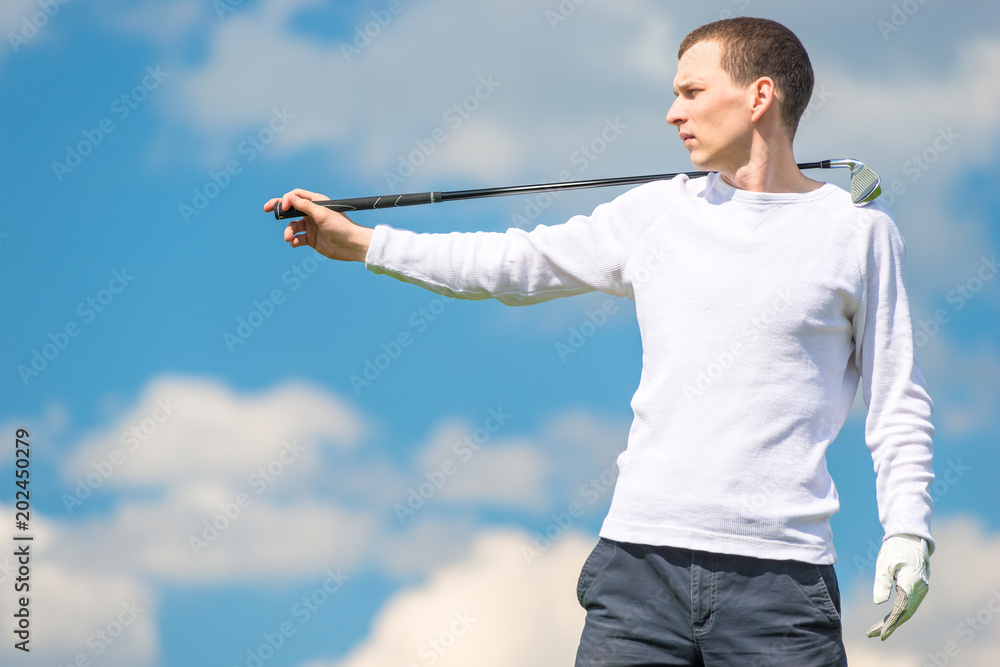 serious golfer professional posing with golf club on blue sky background serious golfer professional posing with golf club on blue sky background