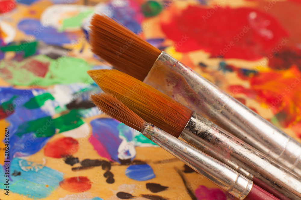Obraz premium Painting. Set of brushes on the palette stained with paints