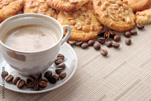 Cup of espresso and cookies with peanuts on light napkin. Copy space for your text. Close-up view.