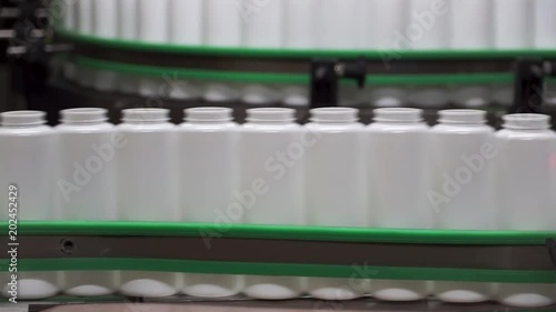 Packed bottle moving on conveyor belt. Clip. Plastic bottle on the conveyor photo