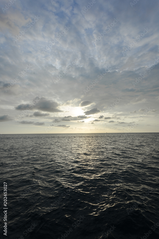 Fototapeta premium cloudy blue sky and sunset on the ocean in the evening